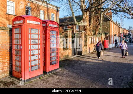 Red public phone boxes on high street, Hartley Wintney, Hampshire, England, GB, UK Stock Photo