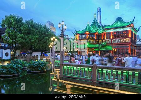 The Huxinting Teahouse in Yu Garden, Shanghai, China at sunset. The structure, sitting on a pond is conected via a zigzag bridge and brightly lightten Stock Photo