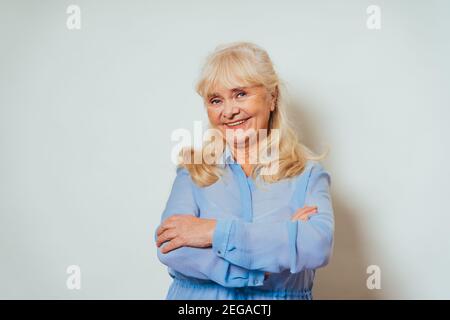 Beautiful senior woman at home and looking at camera smiling - Pretty adult over 60 years old portrait Stock Photo