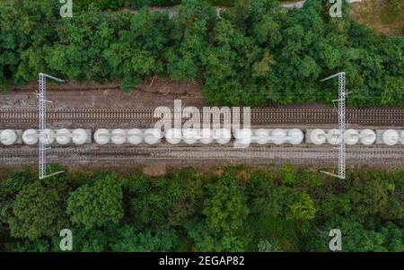 Top down aerial look to driving goods train between trees Stock Photo