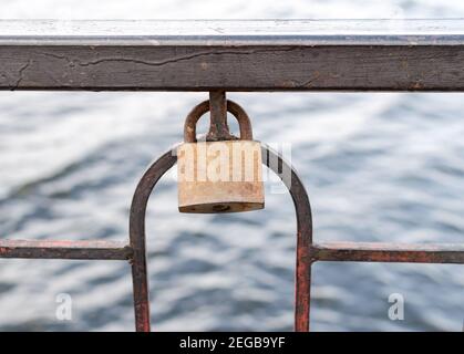 the old castle with rust hangs on the metal railing of the bridge as a sign of the wedding tradition. Stock Photo