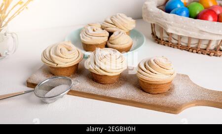 cruffins easter spring pastries, a mixture of muffin and croissant on a light background, the composition Easter painted eggs willow and cake. Stock Photo