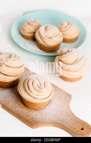 cruffins easter spring pastries, muffin and croissant roll on a light background, close-up for text place. fresh homemade festive kulich. Stock Photo