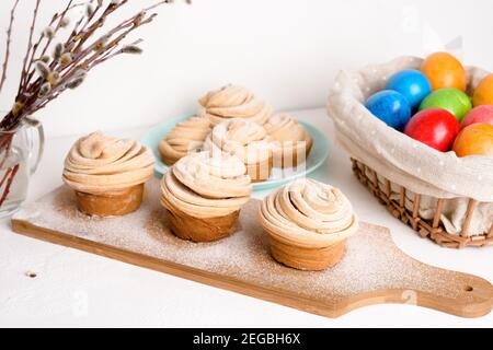 cruffins easter spring pastries, a mixture of muffin and croissant on a light background, the composition Easter painted eggs willow and cake. Stock Photo