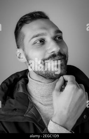Black and white portrait of a young man touching his chin in a moment of inspiration Stock Photo