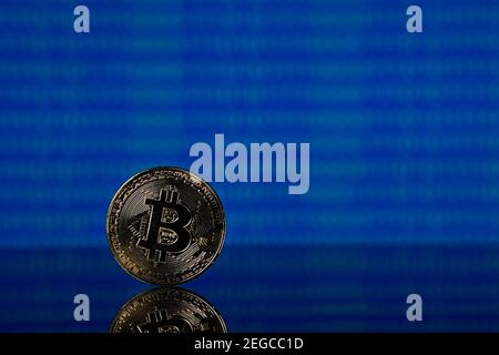 Golden bitcoin, binary code on a blue background Stock Photo