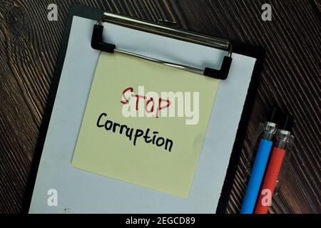 Stop Corruption write on sticky notes isolated on Wooden Table. Business of Finacial concept Stock Photo