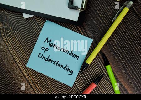 MOU - Memorandum of Understanding write on sticky notes isolated on Wooden Table. Business of Finacial concept Stock Photo