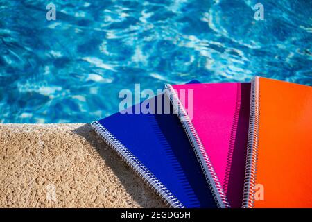 colored notebooks next to a pool Stock Photo