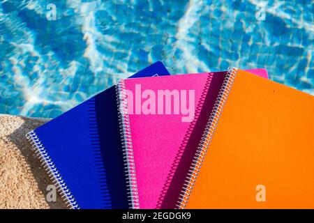 colored notebooks next to a pool Stock Photo