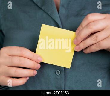Business woman holding a blank yellow memo notepaper, sticky note for copy space, space for text, business,communication,education,design concept Stock Photo