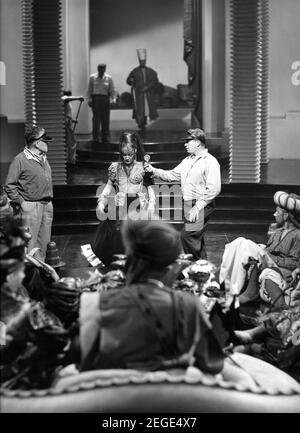 MARLENE DIETRICH on set candid with Cinematographer CHARLES ROSHER (at left) and Film Technician checking light intensity with RONALD COLMAN (centre foreground with back to camera) and HOBART CAVANAUGH (far right) filming KISMET 1944 director WILLIAM DIETERLE play Edward Knoblock screenplay John Meehan hair styles Sydney Guilaroff costume supervisor Irene Metro Goldwyn Mayer Stock Photo