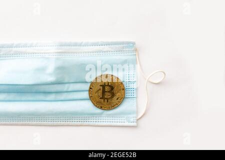 Gold Bitcoin coins with a medical mask Stock Photo