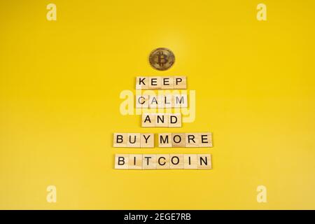 Keep calm and buy more Bitcoin funny sign on yellow background Stock Photo