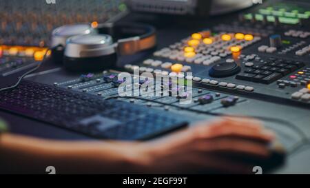 Close Up Shot of Hands of Audio Engineer and Producer Working in Music Recording Studio, Uses Mixing Board Create Modern Song. Stock Photo