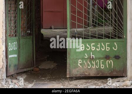 Old gates painted in green with Georgian writings saying: 'Don't park the car' and 'You understand'. Kutaisi, Georgia. Stock Photo