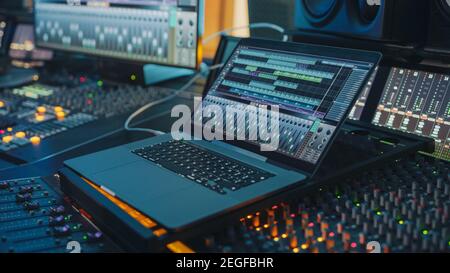 Modern Music Record Studio Control Desk with Laptop Screen Showing User Interface of Digital Audio Workstation Software. Equalizer, Mixer and Stock Photo