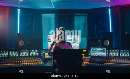 Stylish Artist, Musician, Audio Engineer, Producer Takes Place at His Control Desk in Music Record Studio, Uses Computer Screen show User Interface of Stock Photo