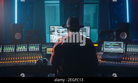 Stylish Artist, Musician, Audio Engineer, Producer Takes Place at His Control Desk in Music Record Studio, Uses Computer Screen show User Interface of Stock Photo