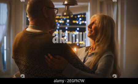 Senior Couple in Love Have Romantic Evening, Dancing in the Dining Room, Celebrating Anniversary. Portrait of a Happy Elderly Husband and Wife Have Stock Photo