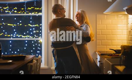 Senior Couple in Love Have Romantic Evening, Dancing in the Dining Room, Celebrating Anniversary. Portrait of a Happy Elderly Husband and Wife Have Stock Photo