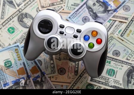 Silver wireless gamepad on dollar bills Stock Photo