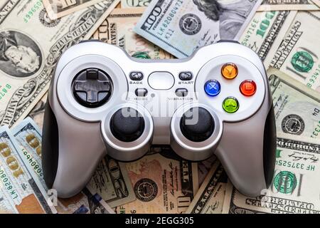 Silver wireless gamepad on dollar bills Stock Photo