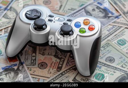 Silver wireless gamepad on dollar bills Stock Photo