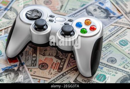 Silver wireless gamepad on dollar bills Stock Photo