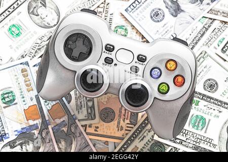 Silver wireless gamepad on dollar bills Stock Photo
