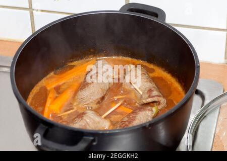 cooking beef roulade in sauce. german beef rolls in pot. Stock Photo