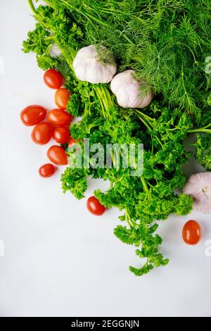Herbs and garlic with tomato on white background. Healthy meal. Stock Photo