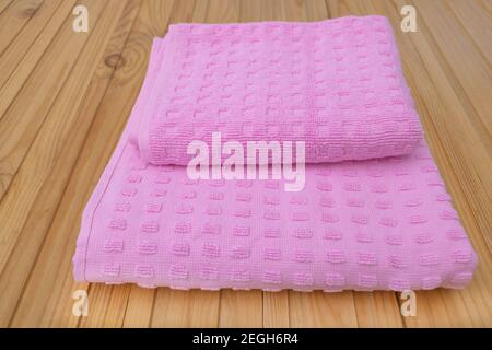 Pink cotton towel on wooden background - Hygiene dry bath cloth. Stock Photo