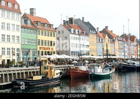 Boats line the canal in front of colorful buildings, central Copenhagen, Denmark March, 2010 Stock Photo