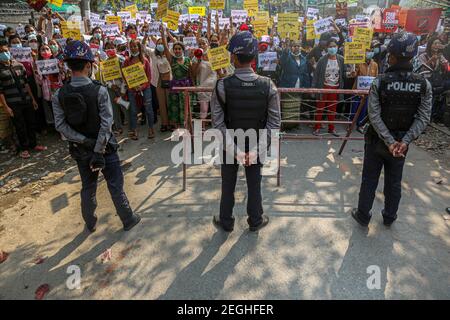 Police standing guard next to a barricade with protesters at the court building.Demonstrators gathered at the court hearing and demanded the release of the detained Mandalay Chief Minister, Dr. Zaw Myint Maung who was charged under section 505 (B) at Aung Myay Tharzan Township court following a lawsuit filed after a statement was issued by the National League for Democracy (NLD) central executive committee on February 1st, according to the court official. The Prime Minister has been detained since February 1st and was arraigned on video conferencing court, according to the prosecutors. Stock Photo