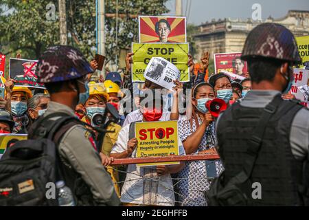 Police standing guard next to a barricade with protesters at the court building.Demonstrators gathered at the court hearing and demanded the release of the detained Mandalay Chief Minister, Dr. Zaw Myint Maung who was charged under section 505 (B) at Aung Myay Tharzan Township court following a lawsuit filed after a statement was issued by the National League for Democracy (NLD) central executive committee on February 1st, according to the court official. The Prime Minister has been detained since February 1st and was arraigned on video conferencing court, according to the prosecutors. Stock Photo