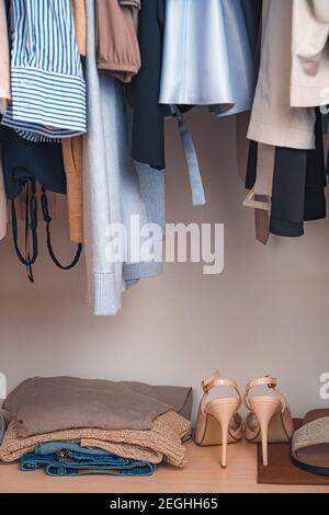 The contents of the cabinet, things on hangers and on the shelf. Stock Photo