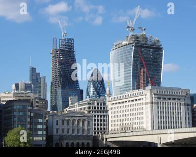 LONDON, ENGLAND - MAY 25: the 'Gherkin' between two skyscrapers under construction in the City of London on May 25, 2013. Stock Photo