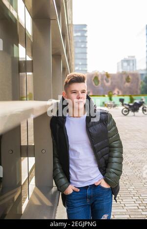 Stylish man standing with hands in pockets, while looking camera Stock Photo