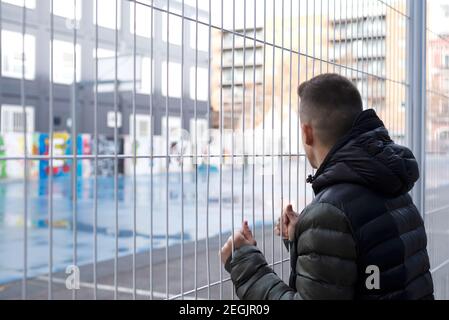 Rear View Of Man Standing By Fence Stock Photo
