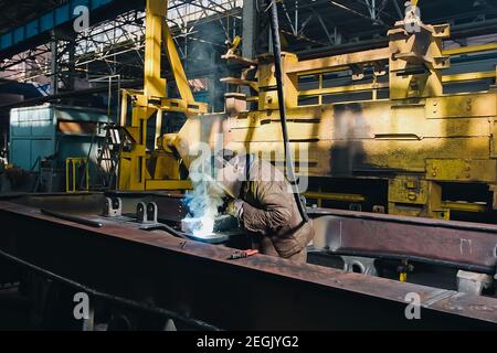 View of railway train manufactory with welder during work on iron Stock Photo