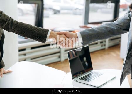 Good job. Close-up of male and female hands, making shaking hands gesture on business briefing meeting, sign an important contract, coming to agreement after negotiations Stock Photo