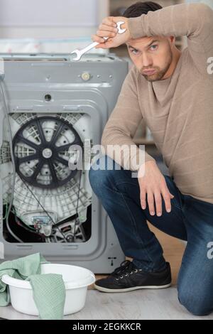 working man plumber repairing a washing machine Stock Photo