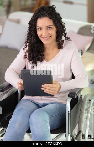 disabled young woman using digital tablet Stock Photo