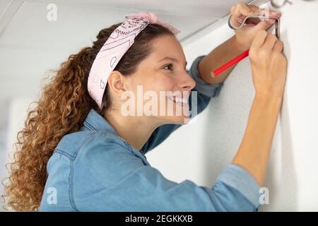 woman checking bracket for curtain rail Stock Photo