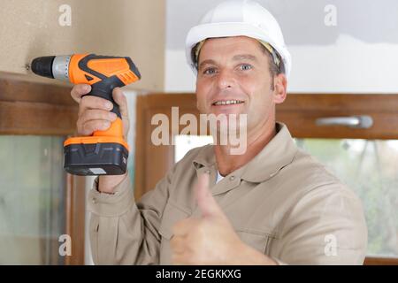 a happy construction worker assembles a window Stock Photo
