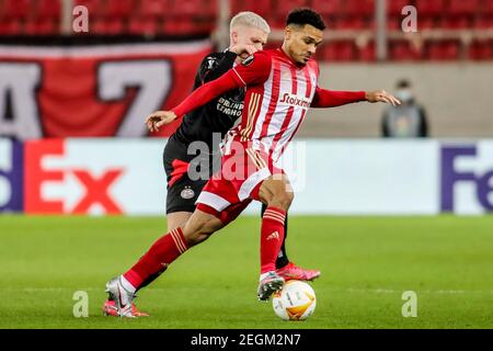 Piraeus, Greece. 18th Feb, 2021. Kenny Lala (R) of Olympiacos vies with Philipp Max of PSV Eindhoven during the UEFA Europa League round of 32 first leg football match between Olympiacos of Greece and PSV Eindhoven of the Netherlands in Piraeus, Greece, Feb. 18, 2021. Credit: Panagiotis Moschandreou/Xinhua/Alamy Live News Stock Photo