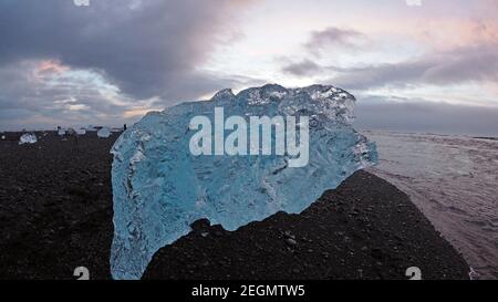 Big iceberg with people on the background at Diamond beach Iceland Stock Photo