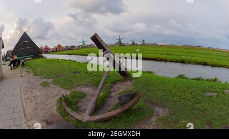 Big anchor in the foreground and windmills in the background at Zaanse Schans, Netherlands - Entrance to the village Stock Photo