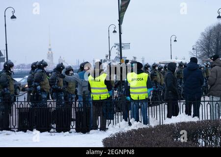 Two members of press in yellow fluorescent vests and the police special squad in uniform during political rally and protests in St. Petersburg, Russia Stock Photo